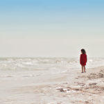 Uma criança olha para o mar